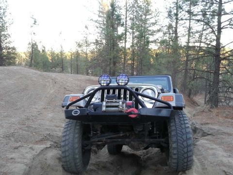 2005 Jeep Wrangler - This Jeep Wrangler is navigating a sandy, off-road trail surrounded by pine trees.