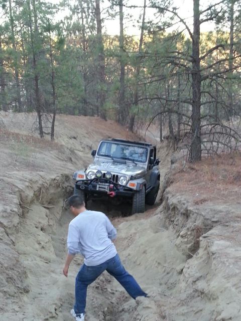 2005 Jeep Wrangler - A Jeep Wrangler navigates a steep dirt path in a wooded area.