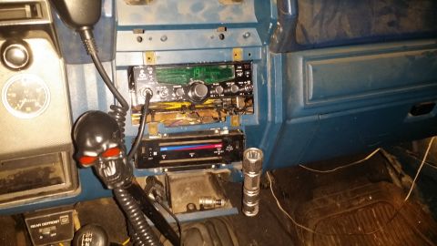 1983 Ford Bronco - The interior of a vehicle features a CB radio, climate controls, and a unique skull gear shift knob.