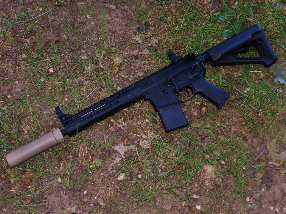 Assault rifle with silencer lying on the ground