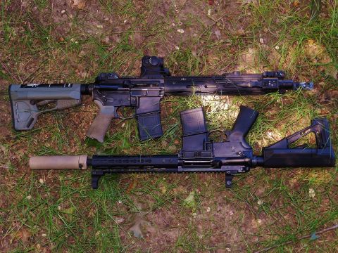 1996 Ford Bronco - Two AR-15 style rifles are shown on a grassy surface.