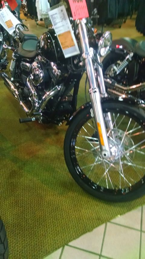 1979 Ford F-150 - A black motorcycle with chrome details is displayed indoors, with price tags attached.