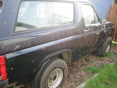 1985 Ford Bronco - This older model Ford Bronco is seen parked outdoors with its hood open.