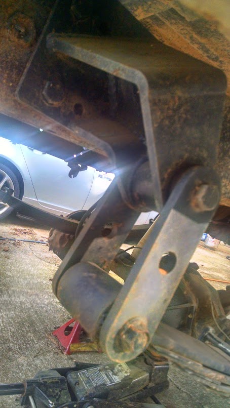 1979 Ford F-150 - This image shows a close-up view of a vehicle's suspension system, focusing on a rusty linkage and frame component.