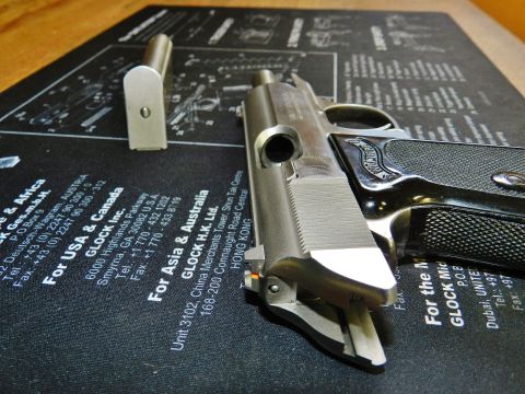 1996 Ford Bronco - Disassembled pistol and magazine shown on a gun cleaning mat with Glock contact details.