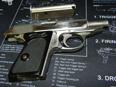 1996 Ford Bronco - A close-up of a pistol and its magazine resting on a gun cleaning mat.