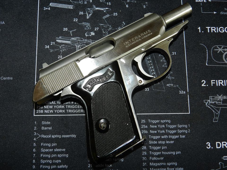 Interarms Walther pistol on a gun schematic mat. Silver slide, black grip