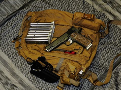 1996 Ford Bronco - A tactical pistol, extra magazines, and accessories are laid out on a backpack.