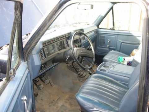 1985 Ford Bronco - Interior view of a blue truck, showing the dashboard, steering wheel, and seats.