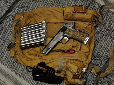 1996 Ford Bronco - A 1911 pistol and its accessories are laid out on a tactical backpack.
