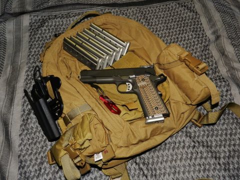 1996 Ford Bronco - Pistol and magazines laid out on a backpack with a patterned cloth underneath.