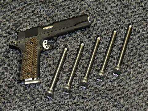 1996 Ford Bronco - A Springfield Armory 1911 pistol is shown with five spare magazines laid out on a textured surface.