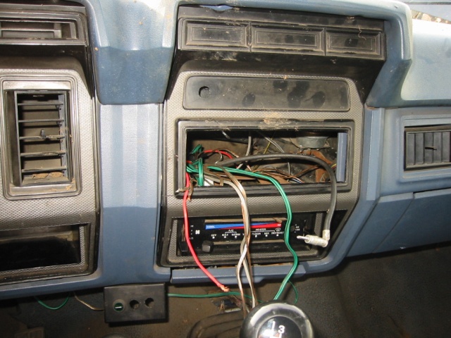 Dashboard with radio removed, showing wires and HVAC controls. Gear shift visible
