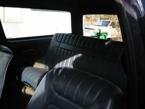 1985 Ford Bronco - Interior view of a vehicle, with another white SUV visible through the rear window.