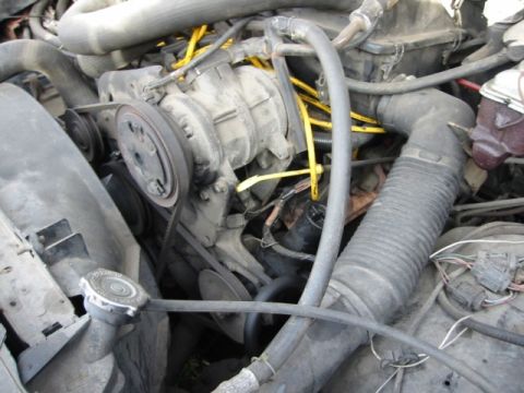 1985 Ford Bronco - Close-up view of an engine bay, focusing on the air intake system and drive belts.