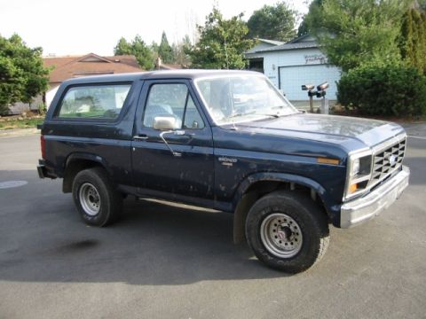 1985 Ford Bronco - This Ford Bronco is parked in a residential area, showing its front three-quarter view.