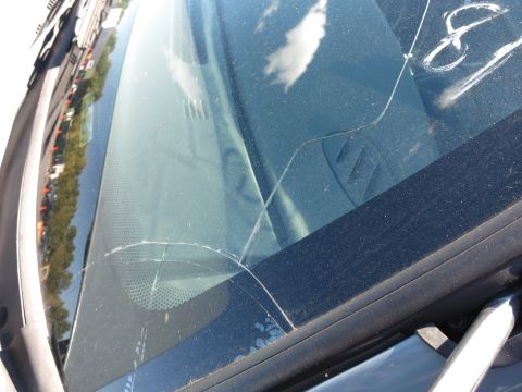 2001 Ford Crown Victoria - A cracked windshield obscures the view of the road and sky, with chalk markings visible on the glass.