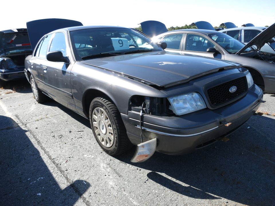 2001 Ford Crown Victoria with hood and trunk open, parked in a lot with other cars
