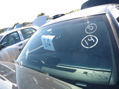 2001 Ford Crown Victoria - A car's windshield displays a paper tag with the number 14 and circled markings, with another vehicle visible in the background.