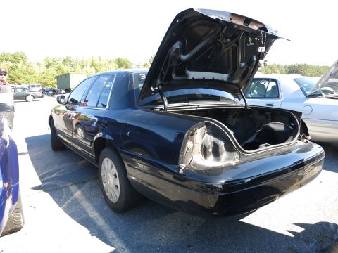 2001 Ford Crown Victoria - A dark blue 2001 Ford Crown Victoria is parked outdoors with its trunk open and a missing taillight.