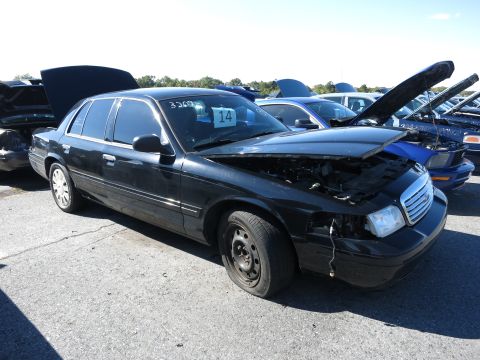 2001 Ford Crown Victoria - Black 2001 Ford Crown Victoria in a lot with other vehicles, hoods open.