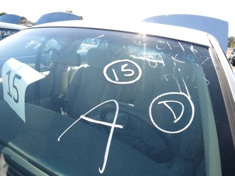 2001 Ford Crown Victoria - The interior of a car is visible through the windshield, which has various chalk markings and a sign with the number 15.