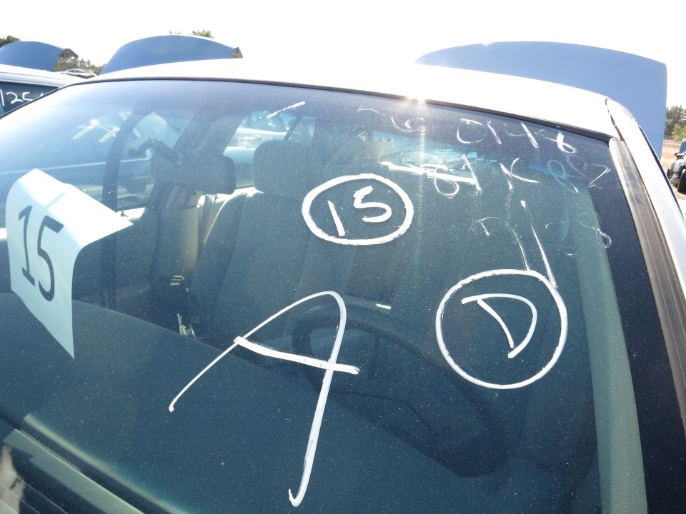 Interior view of a car with a "15" sign and chalk markings "A", "D", and "15" on the windshield