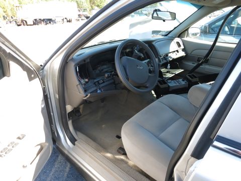2001 Ford Crown Victoria - The interior of a car shows a disassembled dashboard and exposed wiring, with the steering wheel and seats visible.