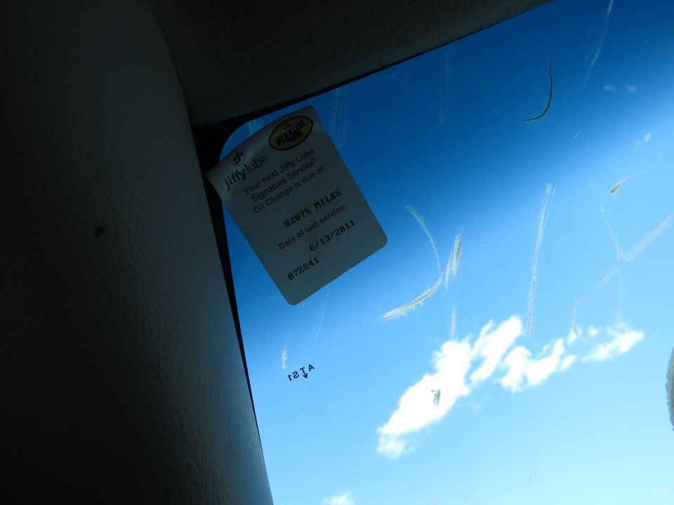 Jiffy Lube oil-change reminder sticker on a windshield corner
