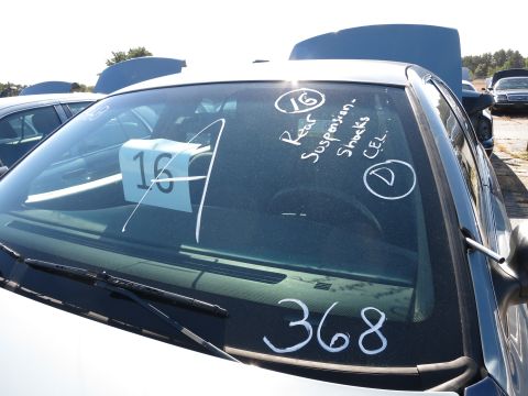 2001 Ford Crown Victoria - Car windshield shows handwritten notes about rear suspension and shocks, along with lot numbers.