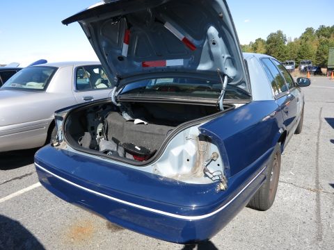 2001 Ford Crown Victoria - Rear view of a blue 2001 Ford Crown Victoria with its trunk open, parked next to a silver Crown Victoria.