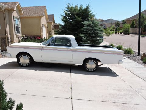 1966 Ford Ranchero - A white pickup truck with distinctive side stripes is parked in a suburban driveway on a sunny day.