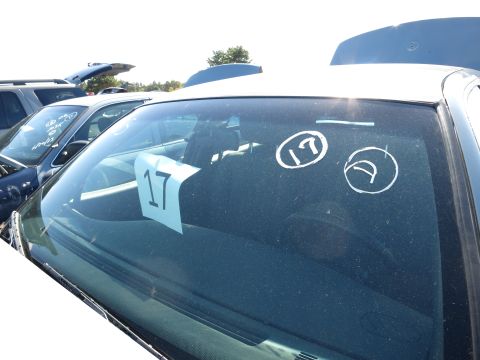 2001 Ford Crown Victoria - Multiple vehicles are parked in an outdoor lot, with one white sedan's windshield prominently displayed.