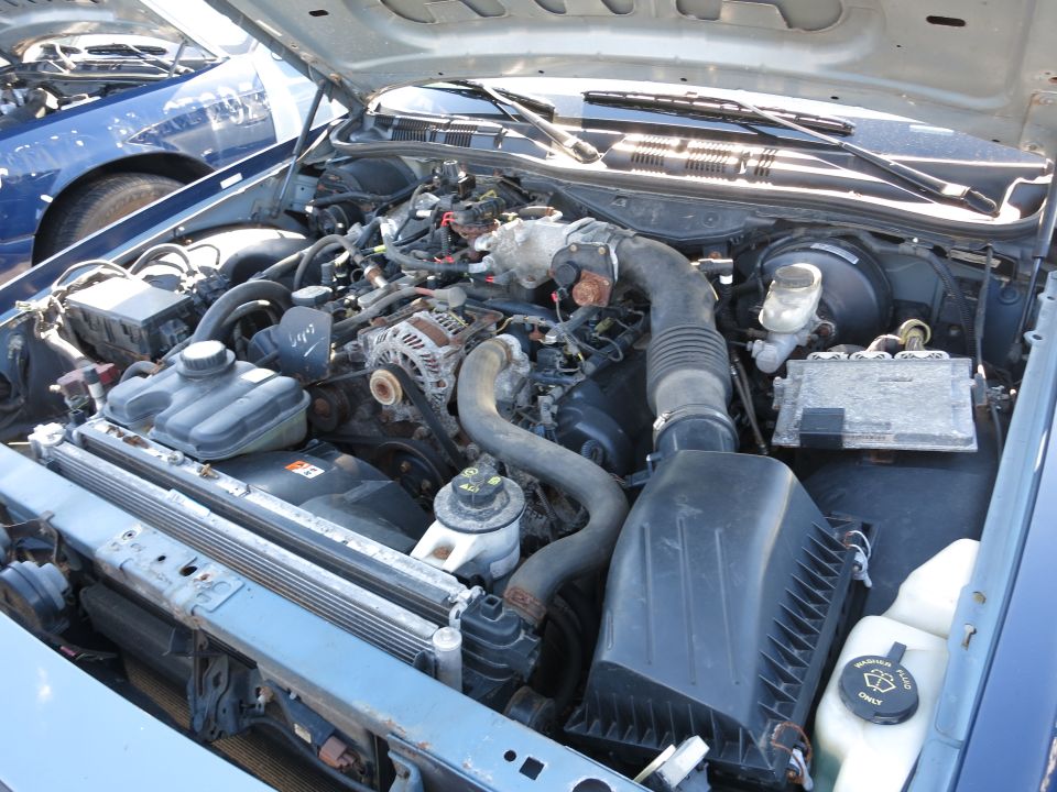 2001 Ford Crown Victoria engine bay with blue car in background