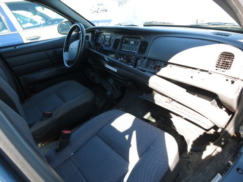 2001 Ford Crown Victoria - The interior of a 2001 Ford Crown Victoria, viewed from the passenger side, reveals the dashboard and seating area.