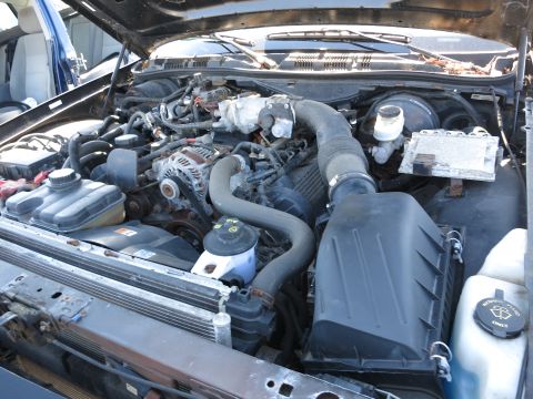 2001 Ford Crown Victoria - The engine bay of a vehicle, showing various components like hoses, belts, and the air intake system.