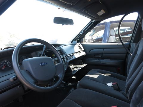 2001 Ford Crown Victoria - Interior of a 2001 Ford Crown Victoria, showing the driver's side controls and passenger seat. Another vehicle is seen outside.