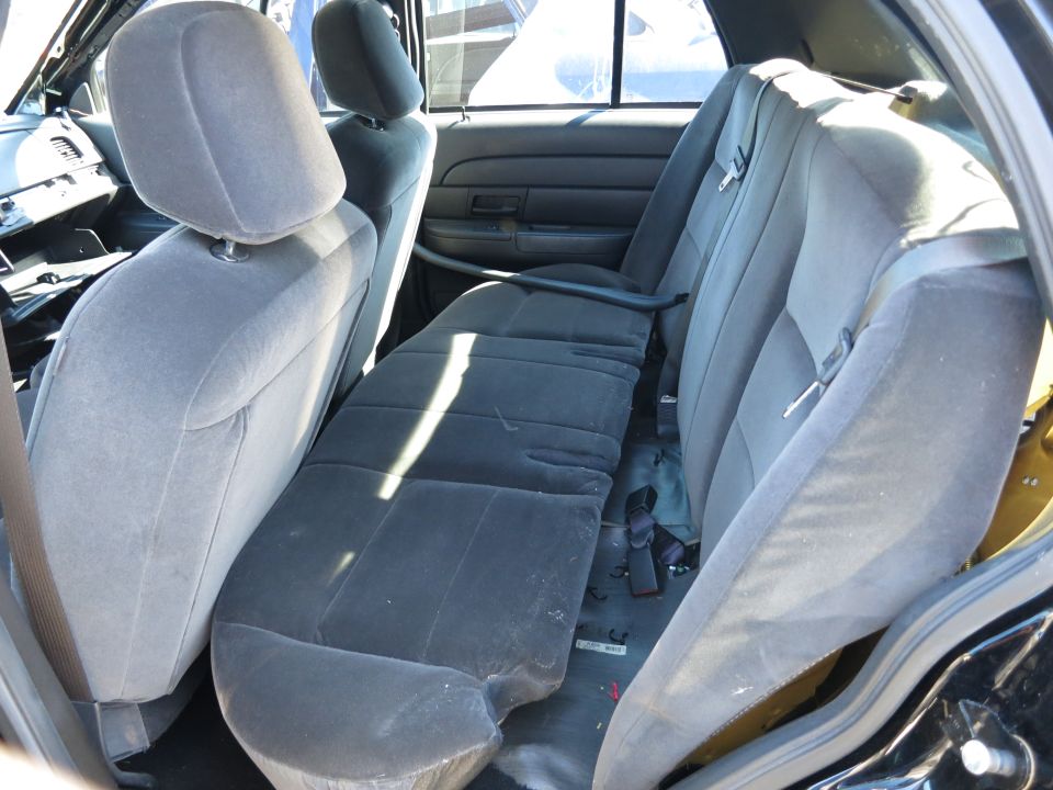 Interior view of a 2001 Ford Crown Victoria, showing the rear bench seat and door panel