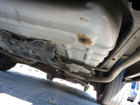 2001 Ford Crown Victoria - The undercarriage of a vehicle is visible, including the fuel tank and exhaust components.