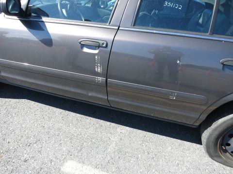 2001 Ford Crown Victoria - The side of a gray 2001 Ford Crown Victoria shows damage and scuff marks on the doors.