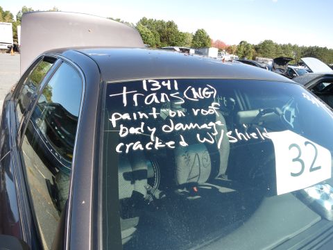 2001 Ford Crown Victoria - A dark sedan is shown with its hood and trunk open, and handwritten notes on the windshield indicating damage.