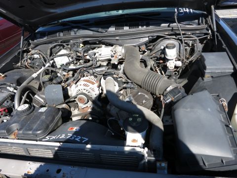 2001 Ford Crown Victoria - The engine bay of a vehicle is shown, with various components and hoses visible. Serial numbers are marked on parts of the engine.
