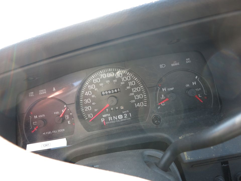 Car dashboard with speedometer, fuel gauge, voltage meter, temperature gauge, and oil pressure gauge. Odometer reads 069341