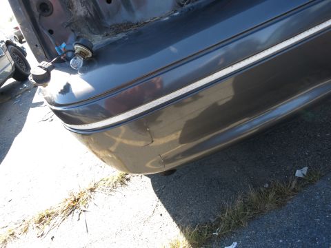 2001 Ford Crown Victoria - The rear bumper and taillight assembly of a 2001 Ford Crown Victoria are visible in this image.