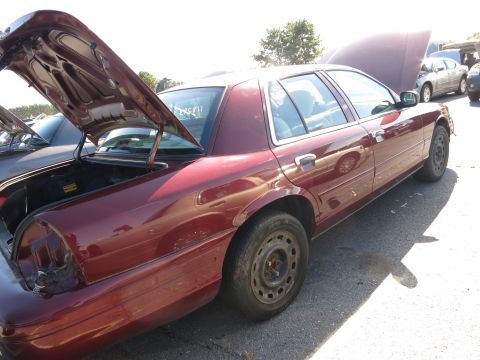 2001 Ford Crown Victoria - A maroon sedan sits with its trunk and hood open, parked outdoors.