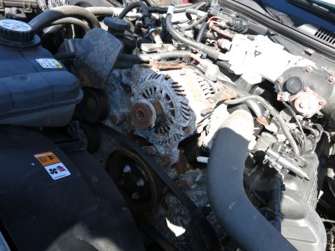 2001 Ford Crown Victoria - The engine bay shows a corroded alternator and various hoses and components.