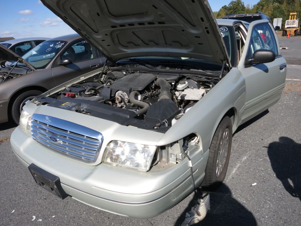 Silver 2001 Ford Crown Victoria with hood open, showing engine and front grille