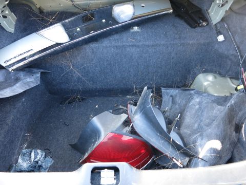 2001 Ford Crown Victoria - The trunk interior contains disassembled parts, including a taillight and a trim piece with the 'Crown Victoria' emblem.