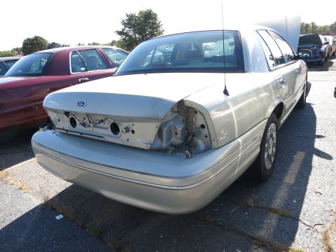 2001 Ford Crown Victoria - Rear view of a 2001 Ford Crown Victoria showing damage to the taillight area. Another similar car is visible.