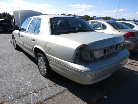 2001 Ford Crown Victoria - This sedan appears to be a 2001 Ford Crown Victoria, missing its rear bumper and with the hood open.